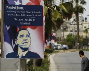 A Palestinian man walks near placards designed by an activist depicting U.S. President Obama, ahead of his visit to the region, in Ramallah