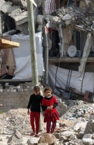 Palestinian girls walk past buildings in Gaza Thomas Coex AFP Getty